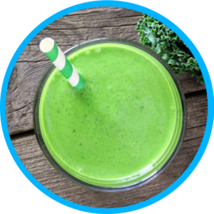 Overhead shot of a green smoothie in a glass tumbler and a green striped straw sticking out.