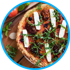 An overhead shot of a thick crust pizza topped with a curry sauce, dates, olives, mozzarella cheese and arugula.