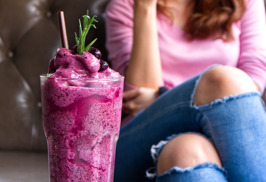 woman-sitting-behind-fruit-smoothie-featured-image